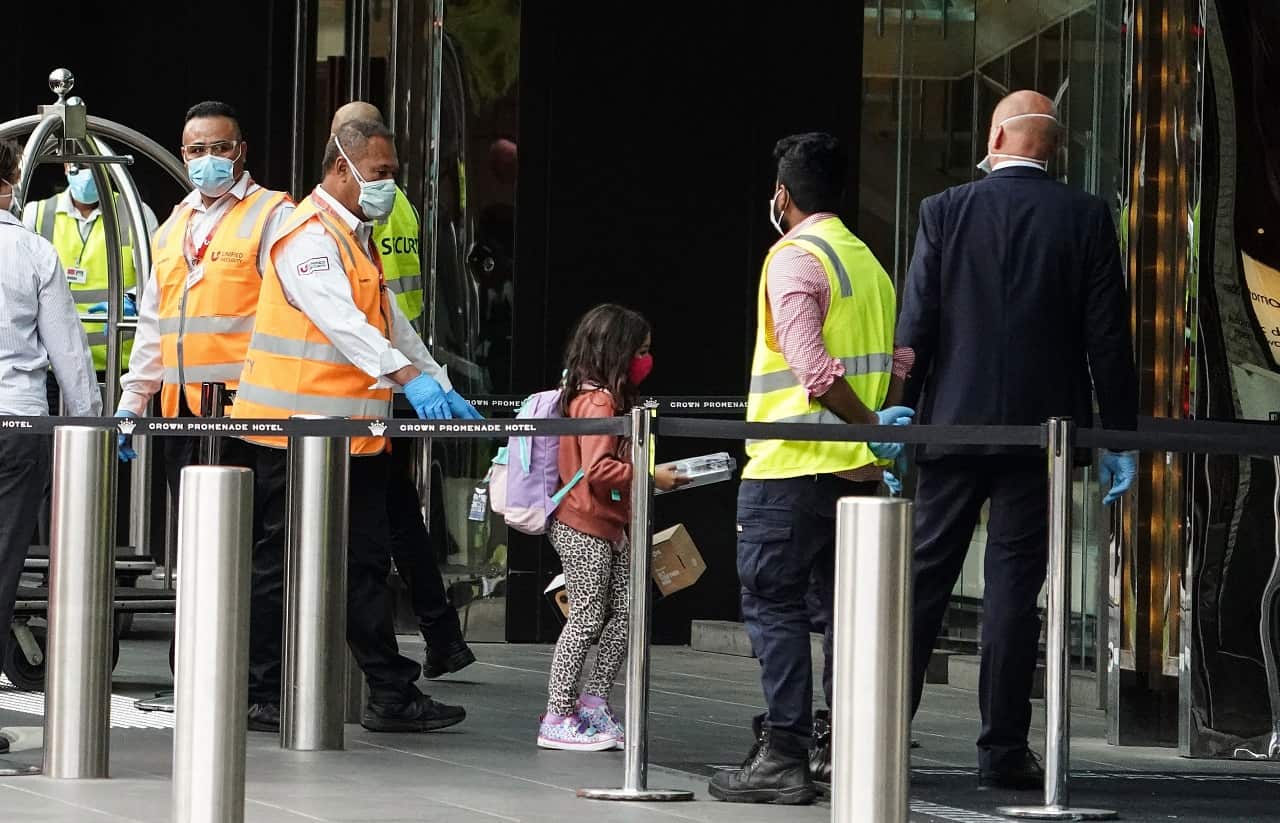Recently arrived overseas travellers get off their bus and wait to check in at the Crown Promenade Hotel in Melbourne, Sunday, March 29, 2020.