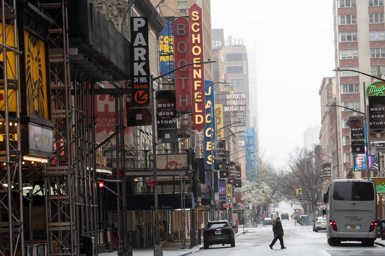 A pedestrian makes his way across 46th Street, Sunday, March 29, 2020, in New York's Times Square. (AP Photo/Mary Altaffer)