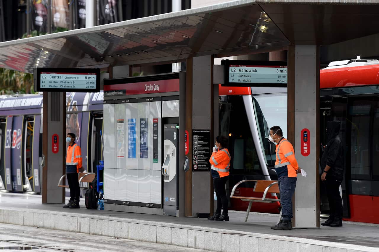 Cleaners are seen at the Circular Quay light rail station in Sydney