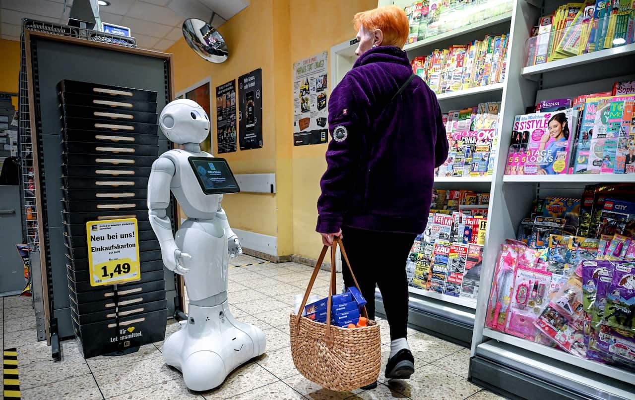 A robot helps customers keep a safe distance between each other in order to minimise transmission of COVID-19 in Germany.