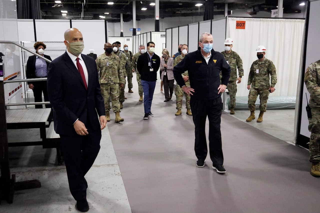 U.S. Sen. Cory Booker, D-N.J., left, and New Jersey Gov. Phil Murphy, right, tour the Edison Field Medical Station at the site of the N.J. Convention