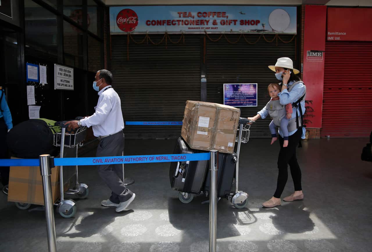Hundreds of Australians stranded in Nepal for weeks leave on repatriation flight. Nepals prime minister to decide on extending lockdown that is scheduled to end tomorrow after 45 days of closure.  (AP Photo/Niranjan Shrestha)