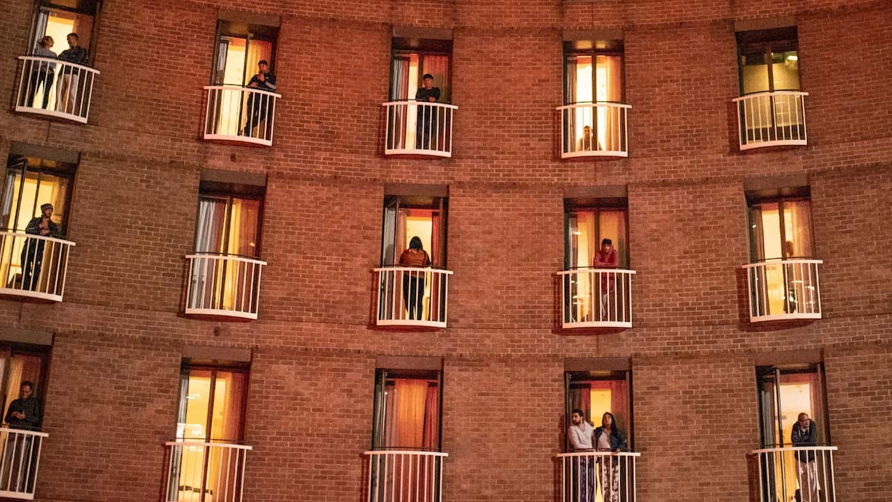 Quarantined hotel guests on balconies