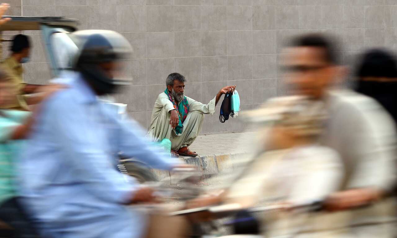 A man sells protective masks on a roadside in Karachi, Pakistan, 22 June 2020.