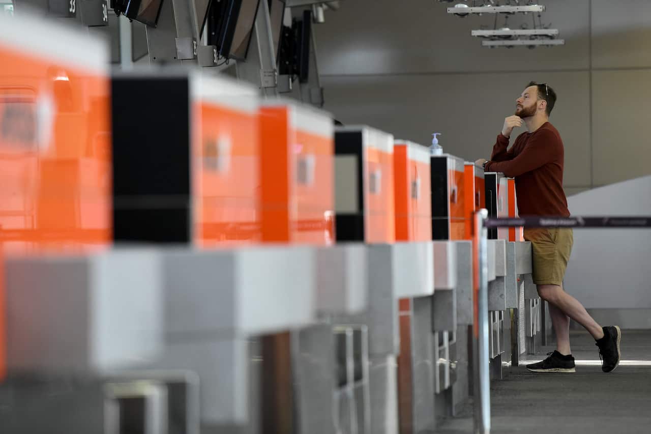 A passenger is seen at the Jetstar check -in counter at Sydney Airport, Sydney, Thursday, July 9, 2020. Passengers on a Jetstar flight from Melbourne to Sydney disembarked without a COVID-19 health screening as NSW Health officials were busy with another 