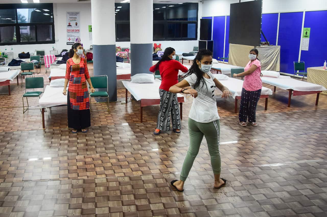 Covid-19 infected patients perform yoga inside an isolation ward at the Commonwealth Games (CWG) Village sports complex which was temporarily converted into a coronavirus care centre in New Delhi. (Photo by Manish Rajput / SOPA Images/Sipa USA)
