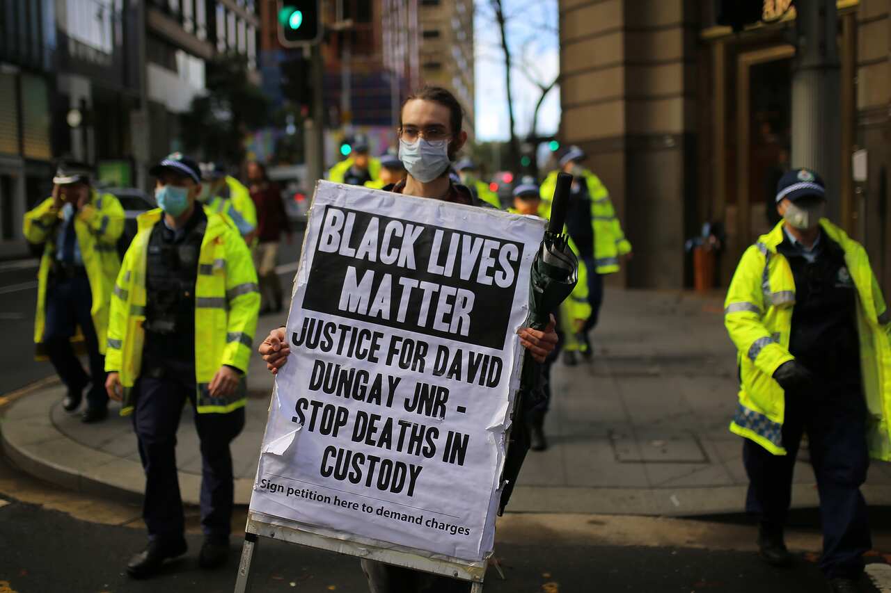 Protestors hold placards during a Black Lives Matter protest in Sydney, Tuesday, July 28, 2020. (AAP Image/Steven Saphore) NO ARCHIVING