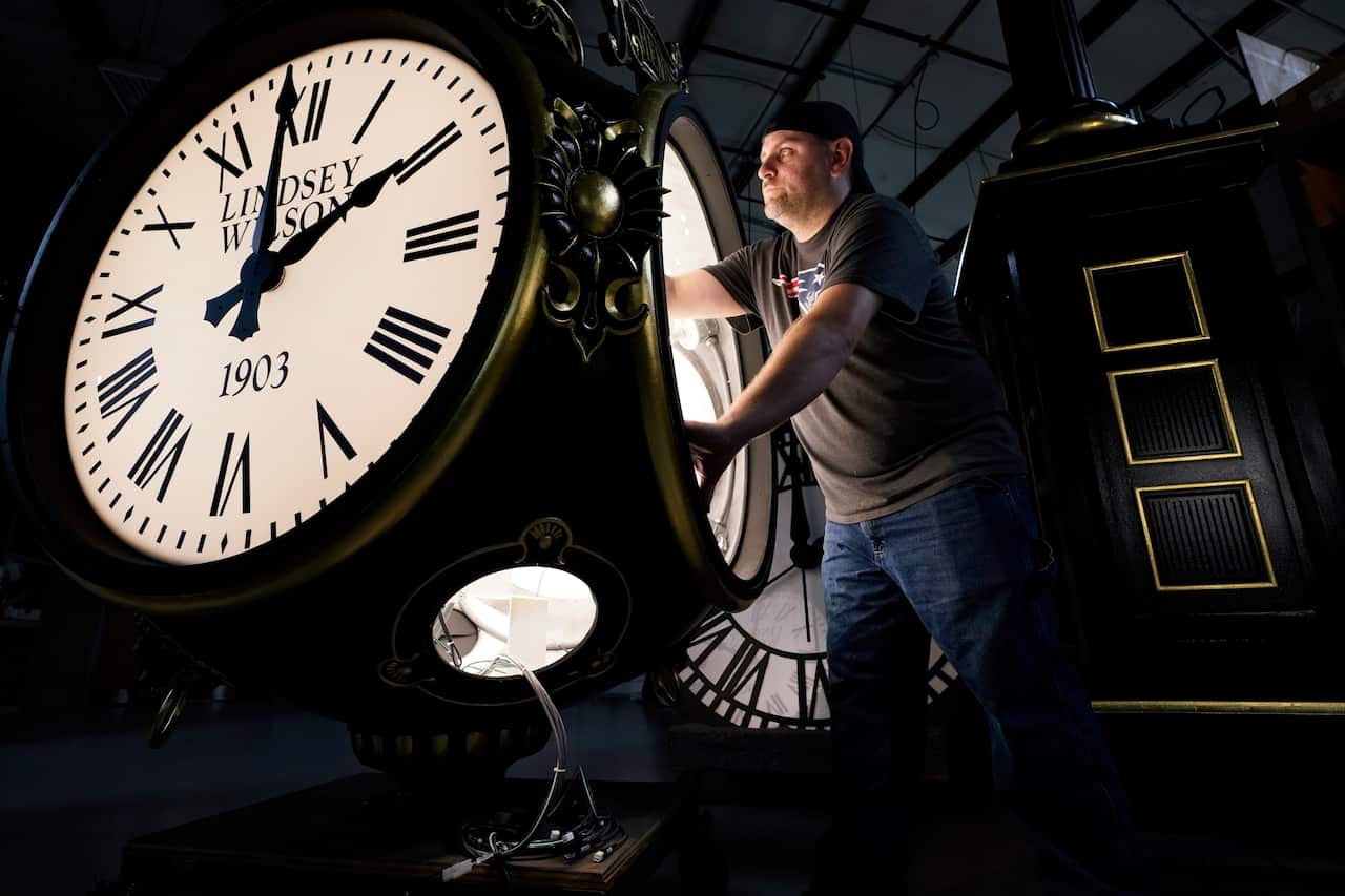 Dan LaMoore works on a Seth Thomas Post Clock at Electric Time Company, Friday, Oct. 23, 2020, in Medfield, Mass. Daylight saving time ends at 2 a.m. local time Sunday, Nov. 1, 2020, when clocks are set back one hour. (AP Photo/Elise Amendola)