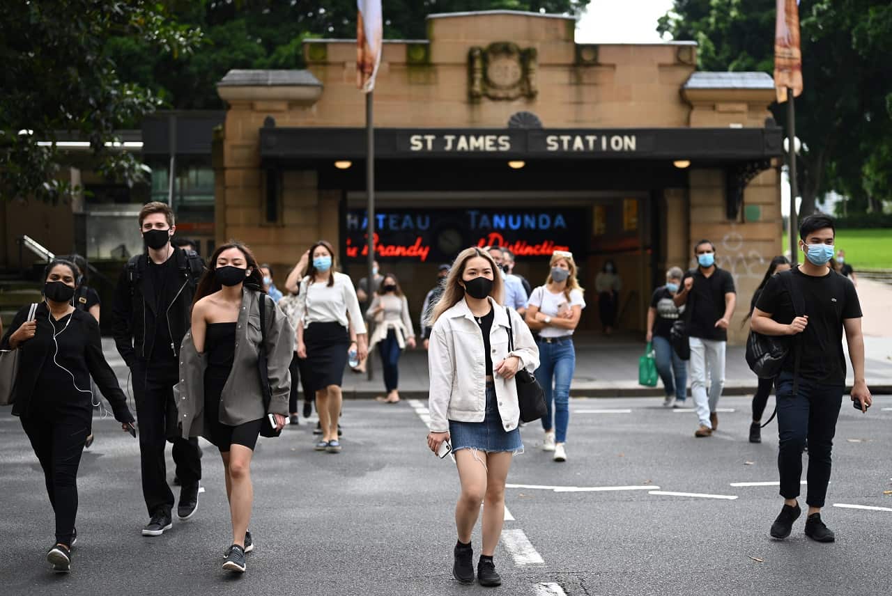 Commuters wearing face masks exit St. James Station in the CBD in Sydney, Monday, January 4, 2021. 