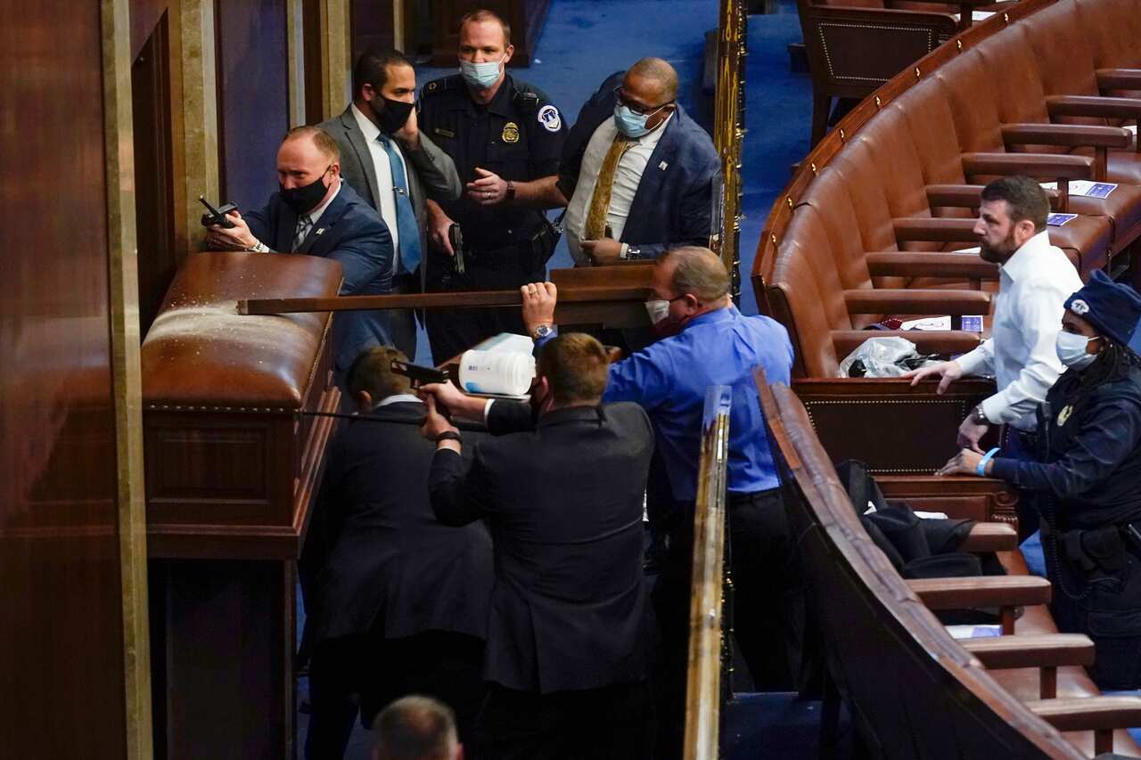 U.S. Capitol Police with guns drawn stand near a barricaded door as protesters try to break into the House Chamber at the U.S. Capitol on Wednesday, Jan. 6, 2021, in Washington. (AP Photo/Andrew Harnik)
