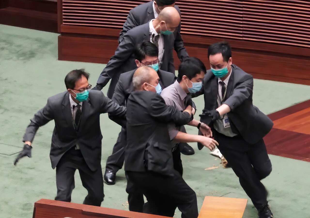 Ted Hui struggles with security staff at Legislative Council after causing disruptions to a debate on a law punishing disrespect for China’s national anthem.