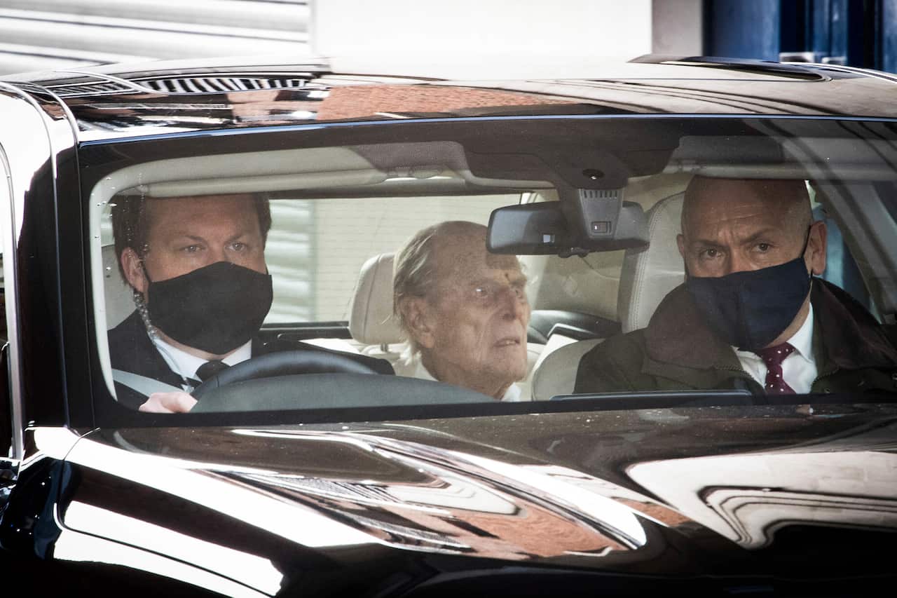 Britain's Prince Philip, centre, as he leaves the King Edward VII hospital in the back of a car in London, Tuesday, March 16, 2021. The 99-year-old husband of Queen Elizabeth II has been hospitalized after a heart procedure. (Stefan Rousseau/PA via AP)