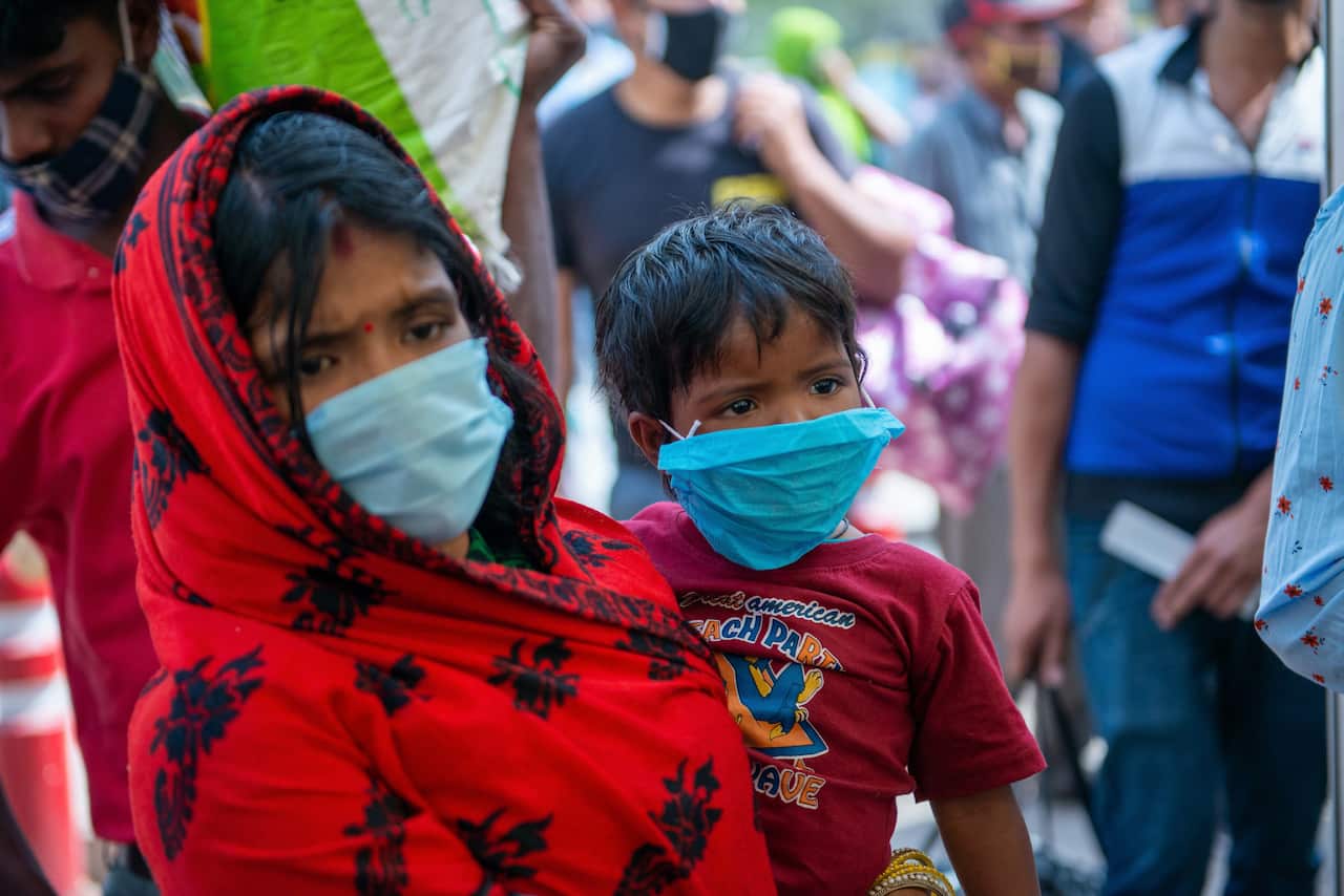 A mother and her child standing in the registration line during the RT PCR test from a Covid-19 testing center at Anand Vihar.