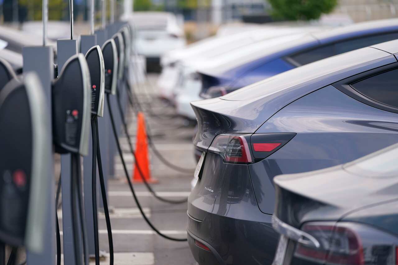 A long line of unsold 2020 models charge outside a Tesla dealership Sunday, Aug. 23, 2020, in Littleton, Colo. (AP Photo/David Zalubowski)