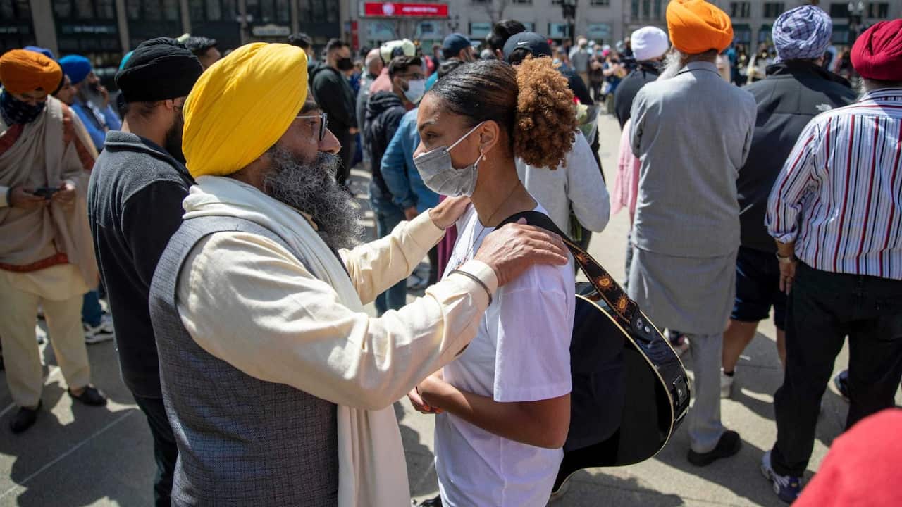 Maninder Singh Walia (left) chats with Taylor Hall on Sunday, April 18, on Monument Circle during a vigil for the eight people killed in FedEx tragedy.