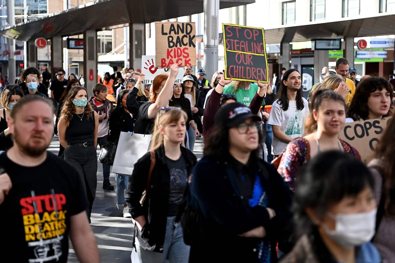 Protestors hold placards as they march through the CBD during a Stop The Stolen Generation! Sorry Day Rally, Sydney, Wednesday, May 26, 2021. (AAP Image/Bianca De Marchi) NO ARCHIVING