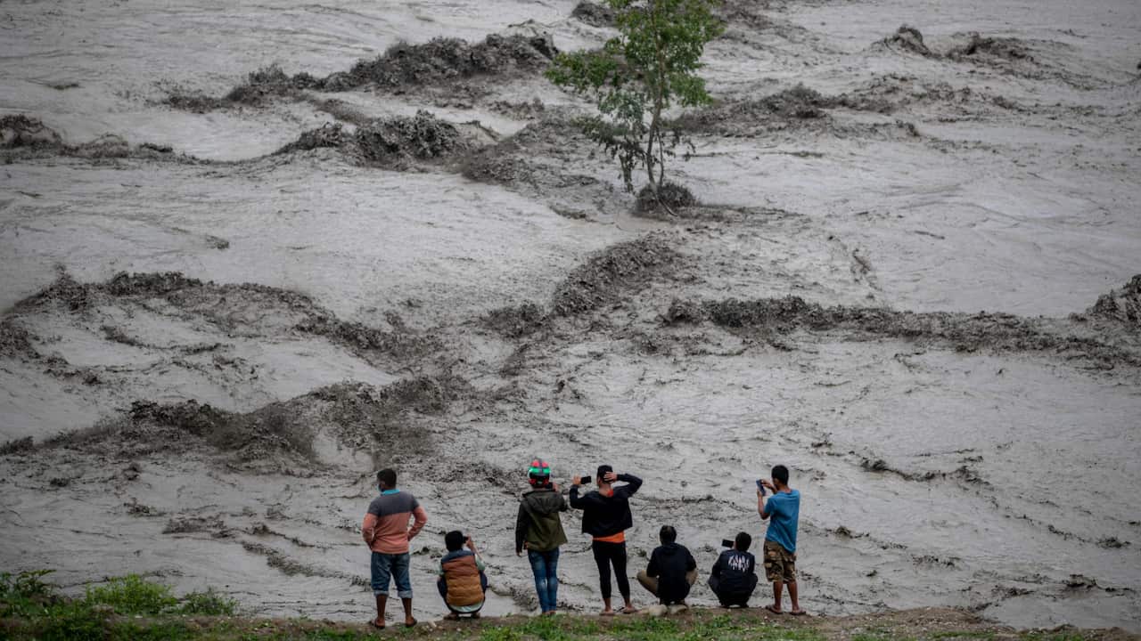 People watch the flooded Melamchi river following torrential rains in Melamchi, Sindhupalchwok district, Nepal, 16 June 2021.
