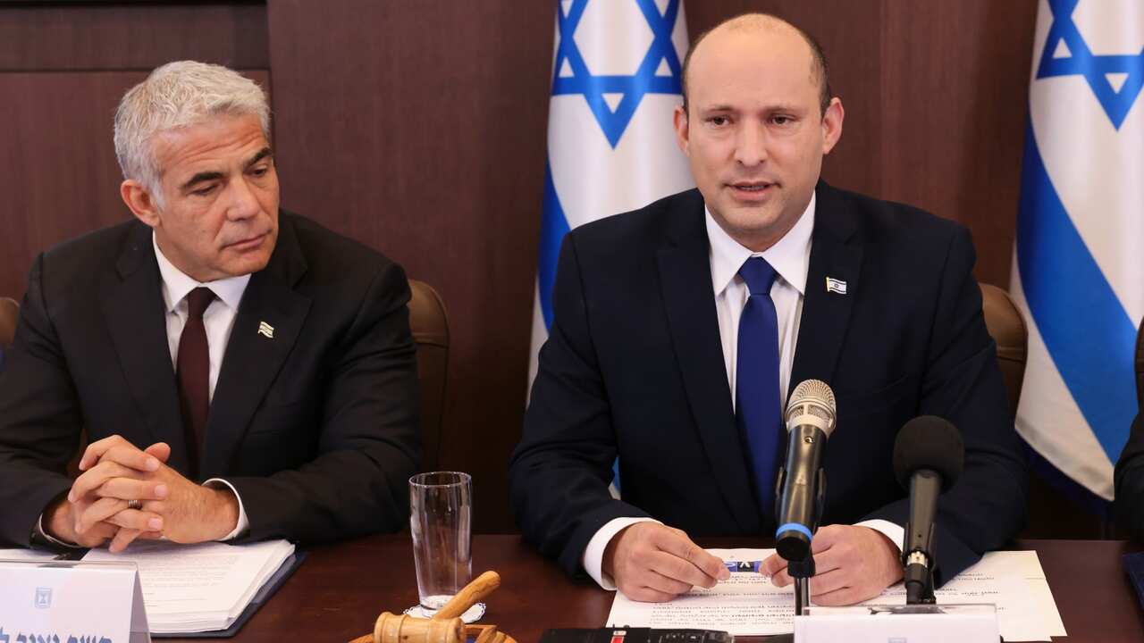 Israeli Prime Minister Naftali Bennett, flanked by Alternate Prime Minister and Foreign Minister Yair Lapid,   