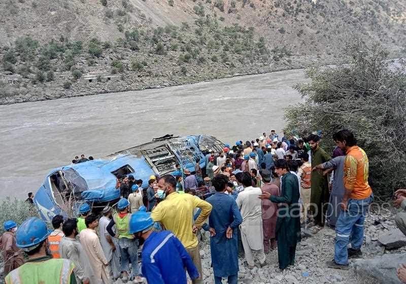 Local residents and rescue workers gather at the site of bus accident, in Kohistan Kohistan district of Pakistan's Khyber Pakhtunkhwa province, Wednesday, July 14, 2021. 