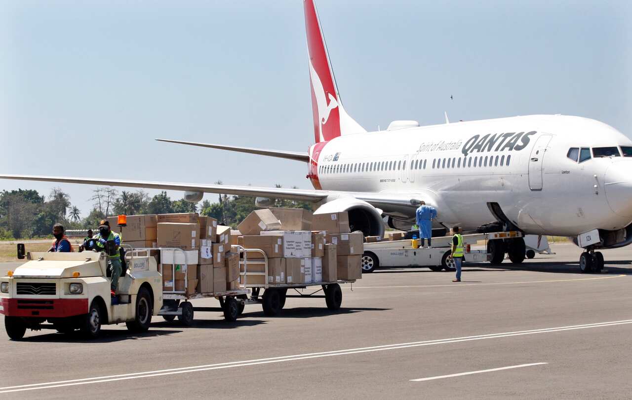 Workers unload AstraZeneca (Vaxzevria) Covid-19 vaccines donated by the Australian government at Nicolau Lobato International Airport in Dili, East Timor