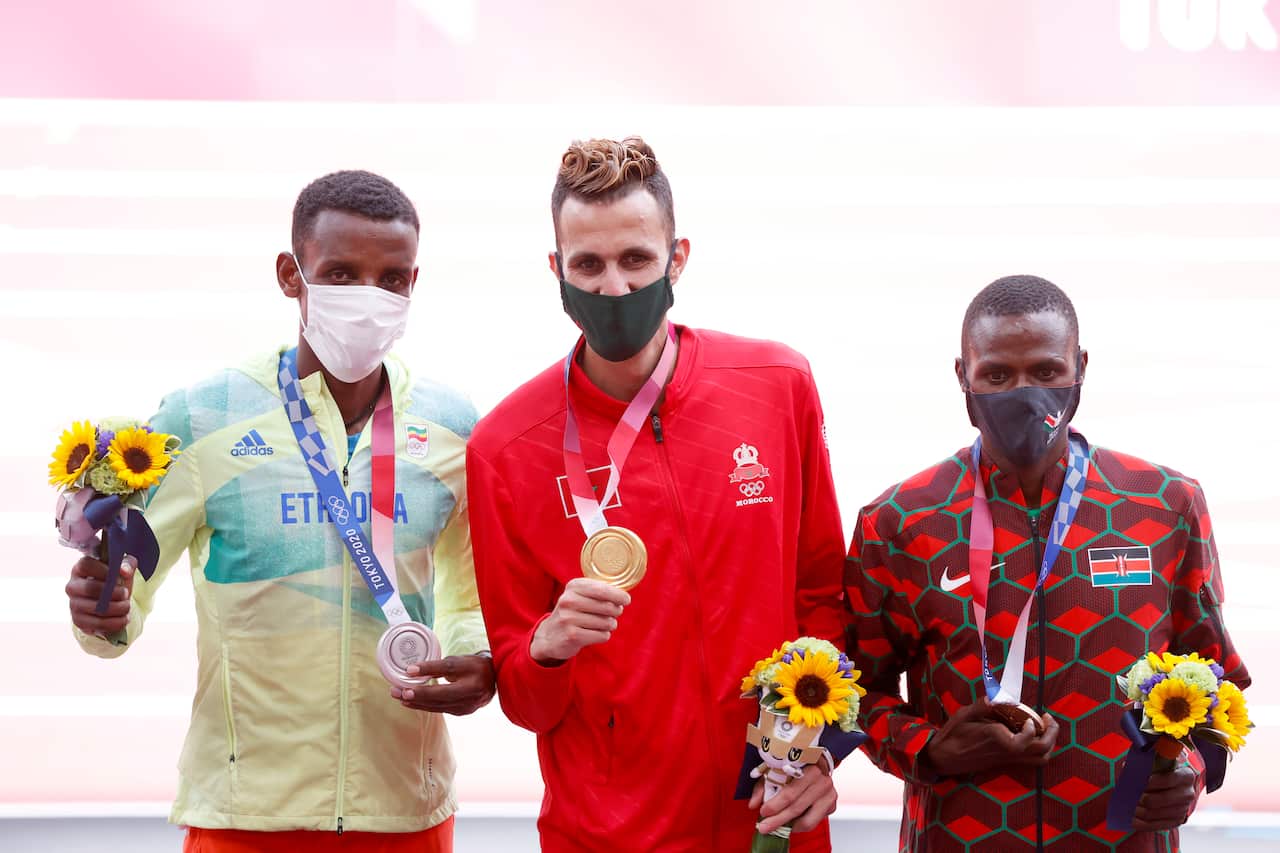 Gold medalist Soufiane El Bakkali (C) of Morocco reacts with Silver medalist Lamecha Girma (L) of Ethiopia and Bronze medalist Benjamin Kigen (R) of Kenya.