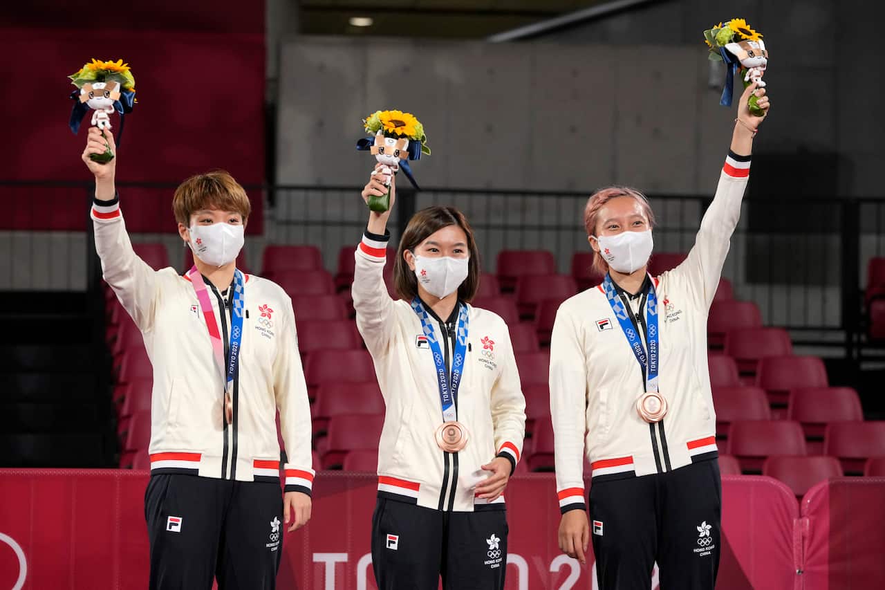 From left, bronze medalists Doo Hoi-kem, Lee Ho-ching, and Minnie Soo Wai-yam of Hong Kong stand during the medal ceremony for women's team table tennis at the 2020 Summer Olympics, Thursday, Aug. 5, 2021, in Tokyo. (AP Photo/Kin Cheung)