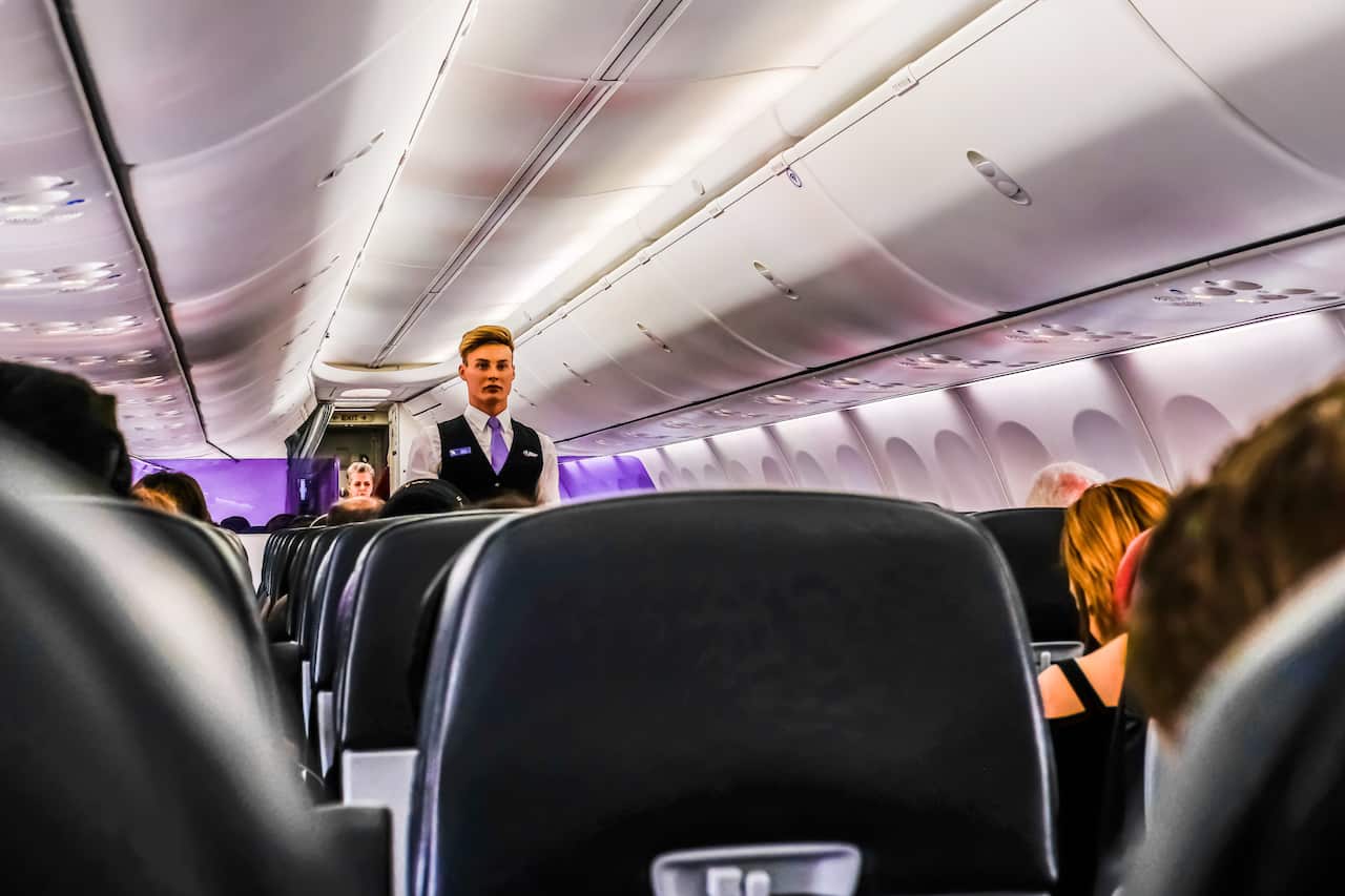 Flight attendant is seen standing in the aisle inside a plane. (Photo by Alexander Bogatyrev / SOPA Image/Sipa USA)