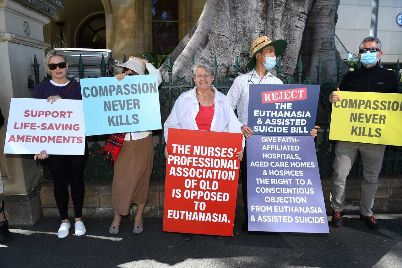 Protesters hold placards during a protest against the Voluntary Assisted Dying bill outside Parliament House in Brisbane, 