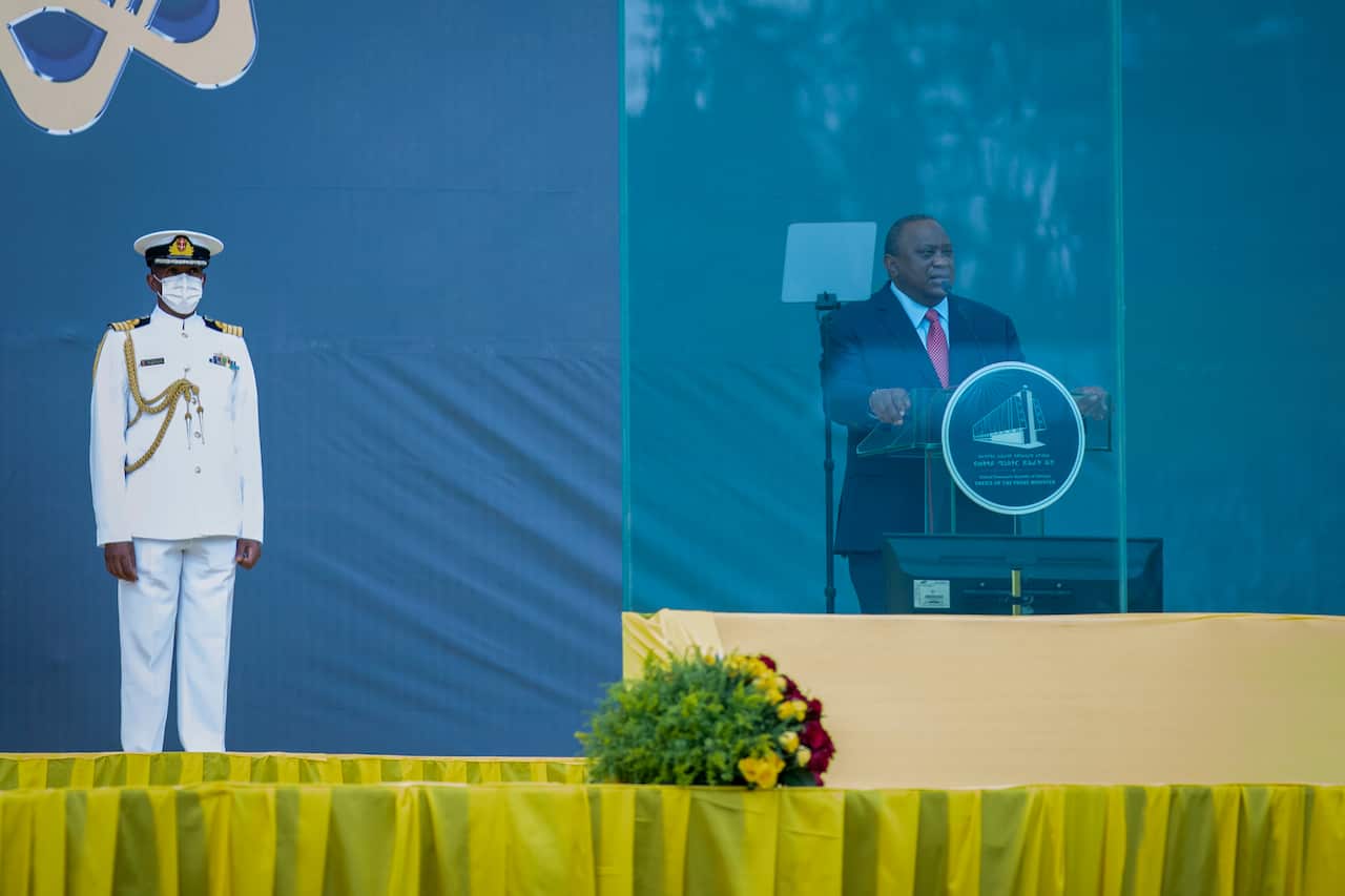 Kenya's President Uhuru Kenyatta speaks behind bulletproof glass at the inauguration ceremony of Ethiopia's Prime Minister Abiy Ahmed, after Abiy was sworn in for a second five-year term, in the capital Addis Ababa, Ethiopia Monday, Oct. 4, 2021. Calls gr