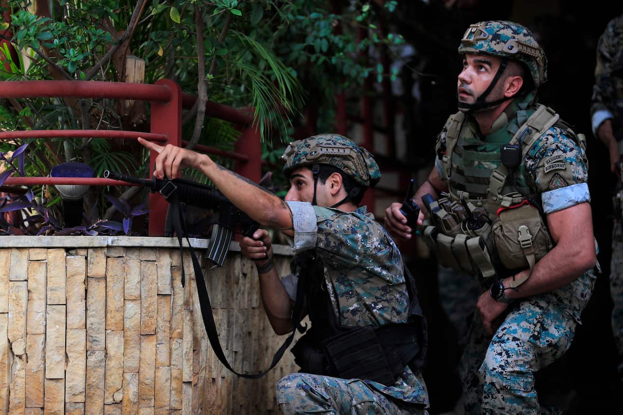Lebanese security forces react to gunfire during a protest in Beirut