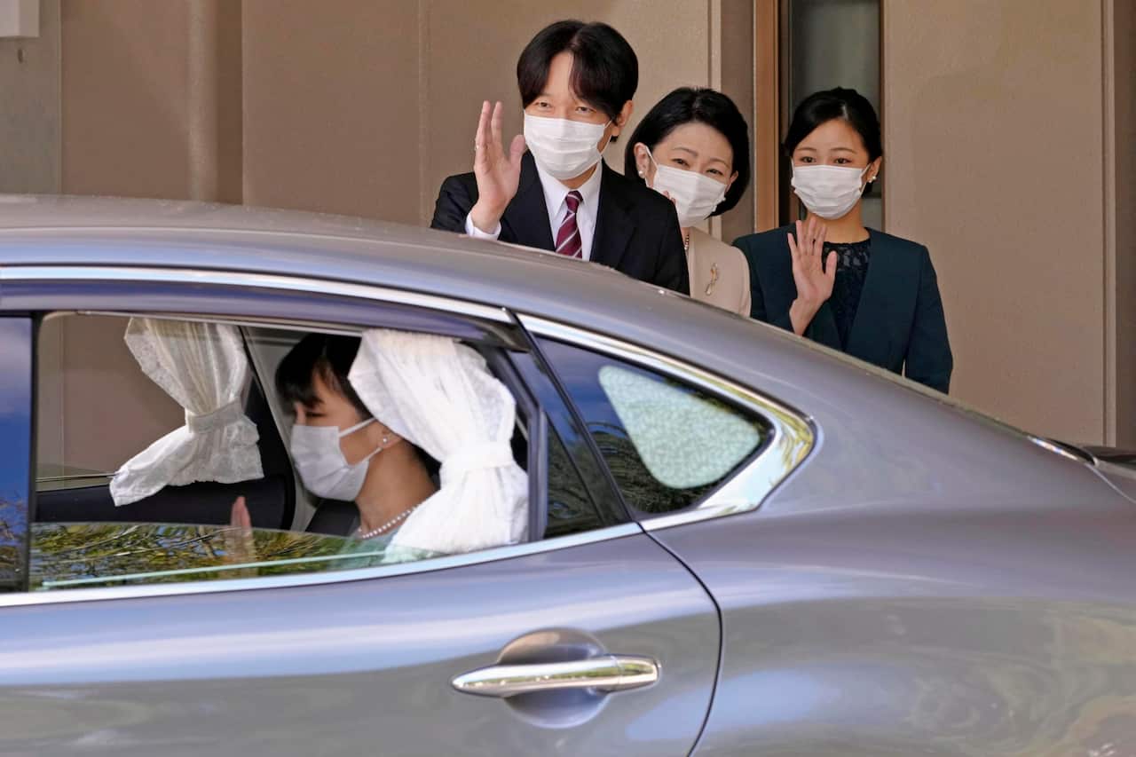 Japan's Crown Prince Akishino, left, Crown Princess Kiko, center, and Princess Kako, right, see off Princess Mako, who is leaving her home in Akasaka Estate in Tokyo Tuesday, Oct. 26, 2021. Princess Mako quietly married commoner Kei Komuro without traditi