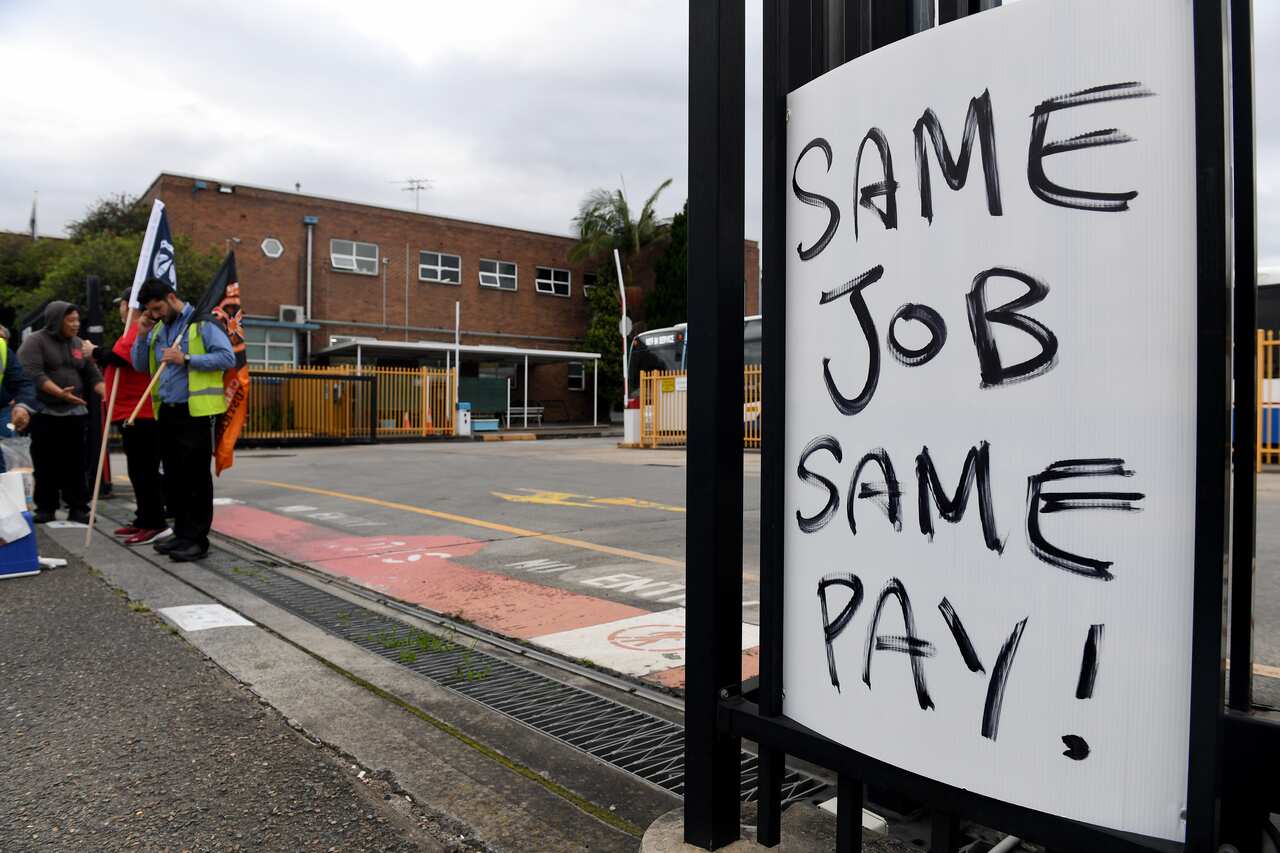 Placards are seen as bus drivers participate in a strike at Burwood Bus Depot in Sydney, Monday, December 6, 2021. Bus drivers in Sydney's Inner West and South West zones are holding a 24-hour strike. (AAP Image/Bianca De Marchi) NO ARCHIVING