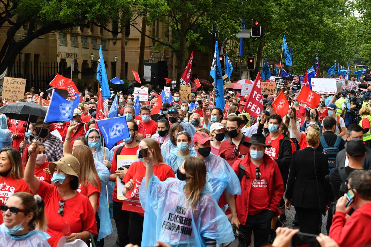 Teachers march to Parliament House during a strike by NSW public school teachers and principals in Sydney, Tuesday, December 7, 2021. NSW teachers are stopping work over staff shortages and uncompetitive salaries.