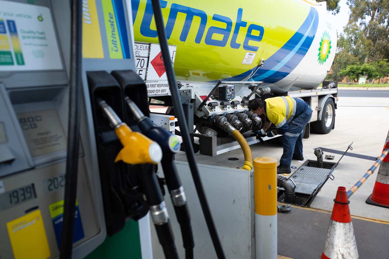 A worker is seen filling the underground tank at a BP Petrol Station in Canberra, Wednesday, December 15, 2021. (AAP Image/Lukas Coch) NO ARCHIVING