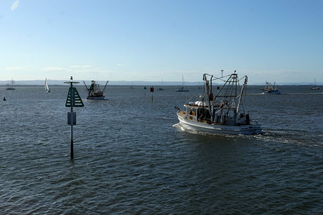 Trawlers head out to sea from the Scarborough Marina  where a plane crashed into nearby waters, north of  Brisbane, Sunday, December 19, 2021. Queensland Police have confirmed two adults and two children have been killed in a light plane crash in waters o