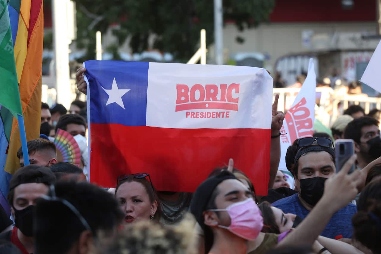 Gente festejando la victoria del candidato presidencial Gabriel Boric, en Santiago de Chile el 19 de diciembre de 2021.
