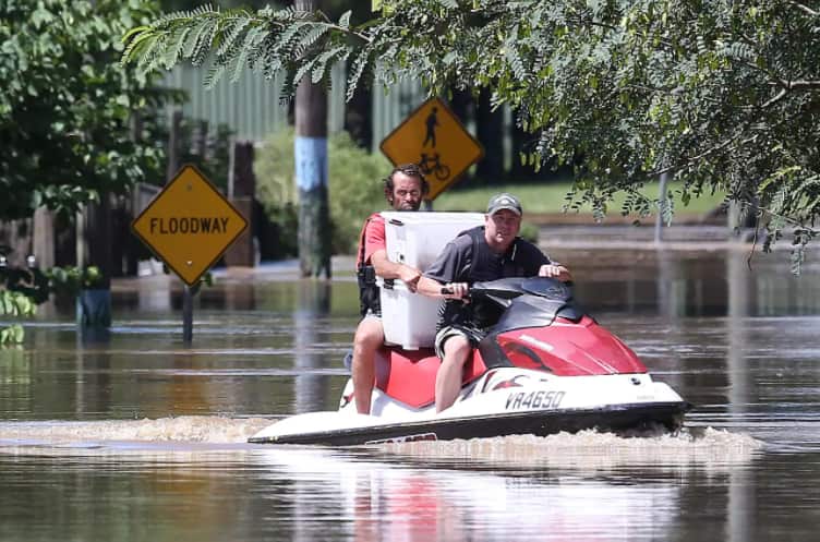 Tony Wartlier (right) helps a flooded resident evacuate his flooded house with animals, in Logan, south of Brisbane, as the suburb reached its peak, Tuesday, 1 March, 2022.