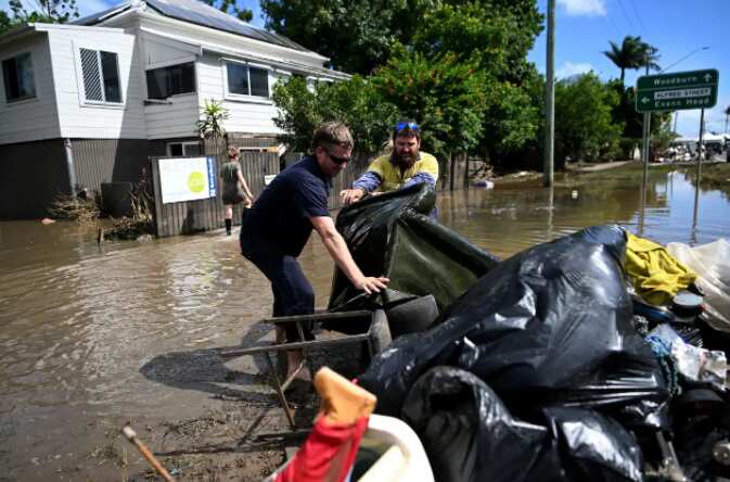 Residents remove damaged items from a flood-affected house on March 7, 2022 in Woodburn, NSW. 