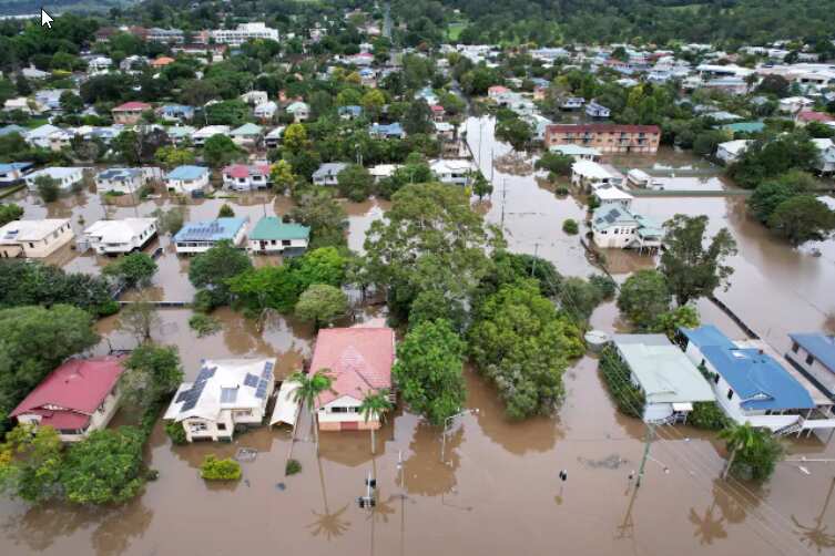 An aerial drone view of houses surrounded by floodwater on March 31, 2022 in Lismore, Australia.