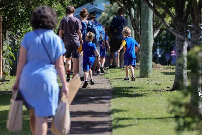 Students are seen entering school grounds for their first day back of the year in Brisbane on 7 February 2022.