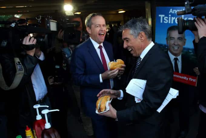 Former Labor leader Bill Shorten bites the middle of a roll at Strathfield North Public School in Sydney in 2016.