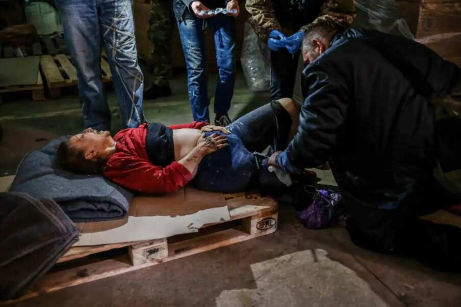 An injured woman receives first aid at a centre for distribution of humanitarian aid in Sievierodonetsk after the city was hit by Russian shelling.
