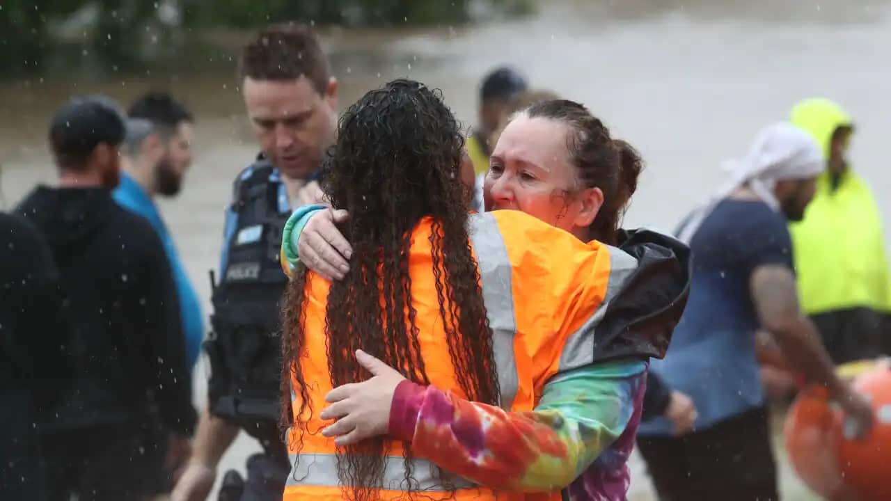 A rescue worker comforts a woman during the floods in Lismore, northeastern NSW.