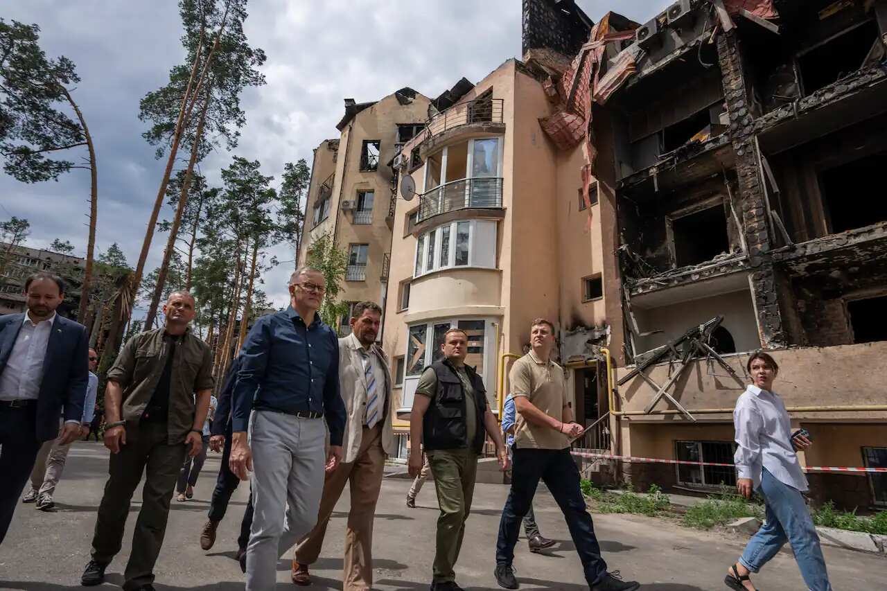Anthony Albanese, third left, looks at apartment buildings damaged by Russian shelling during his visit to Irpin, on the outskirts of Kyiv, Sunday, 3 July 2022.