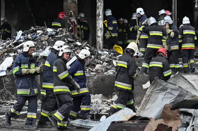 Firefighters gather as they take rubbles out of a damaged building following a Russian airstrike in the city of Vinnytsia, west-central Ukraine, on July 14, 2022.