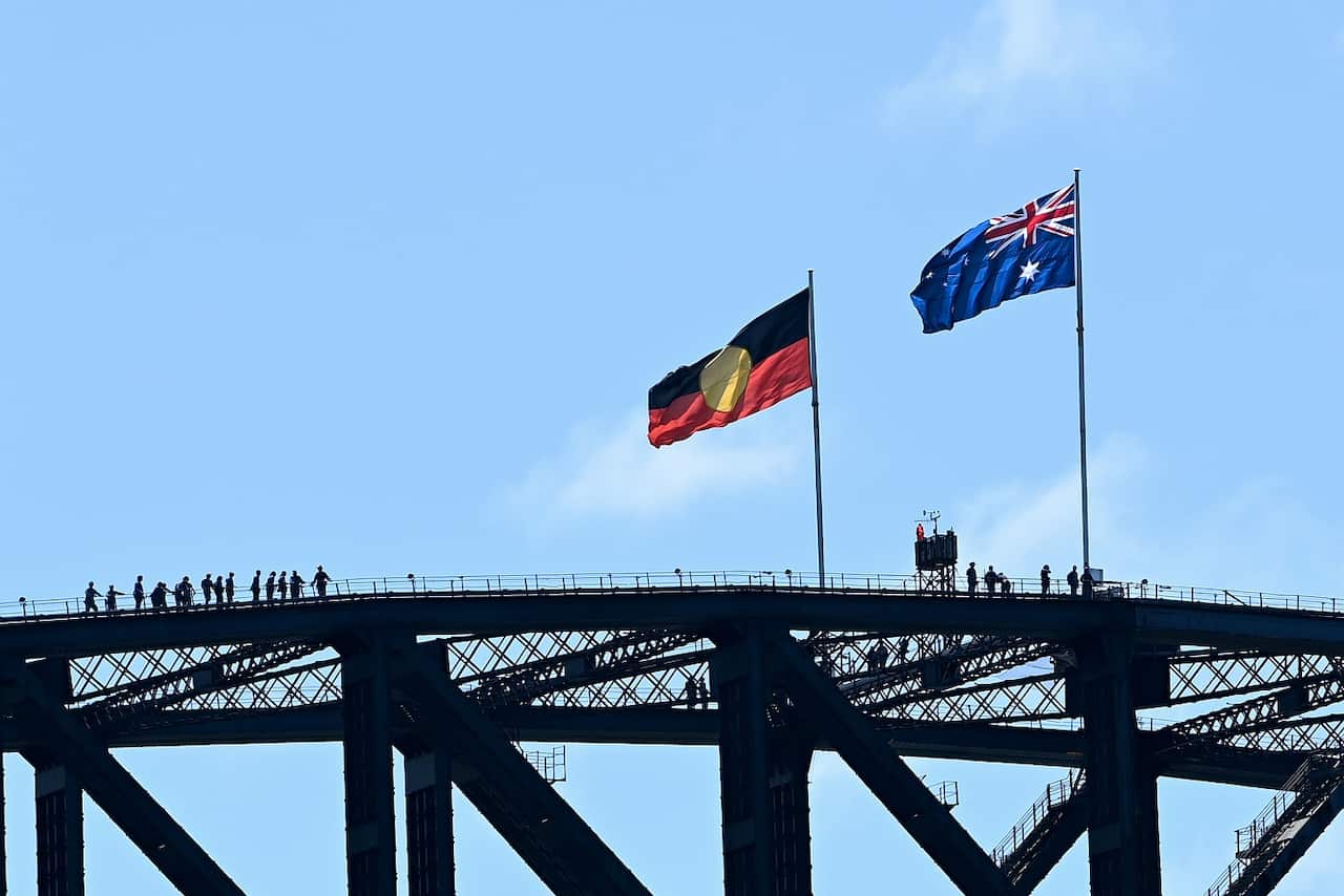 The Australian Aboriginal and Australian national flags are seen on top of the Sydney Harbour Bridge during Australia Day 2022 celebrations, in Sydney, Wednesday, January 26, 2022 