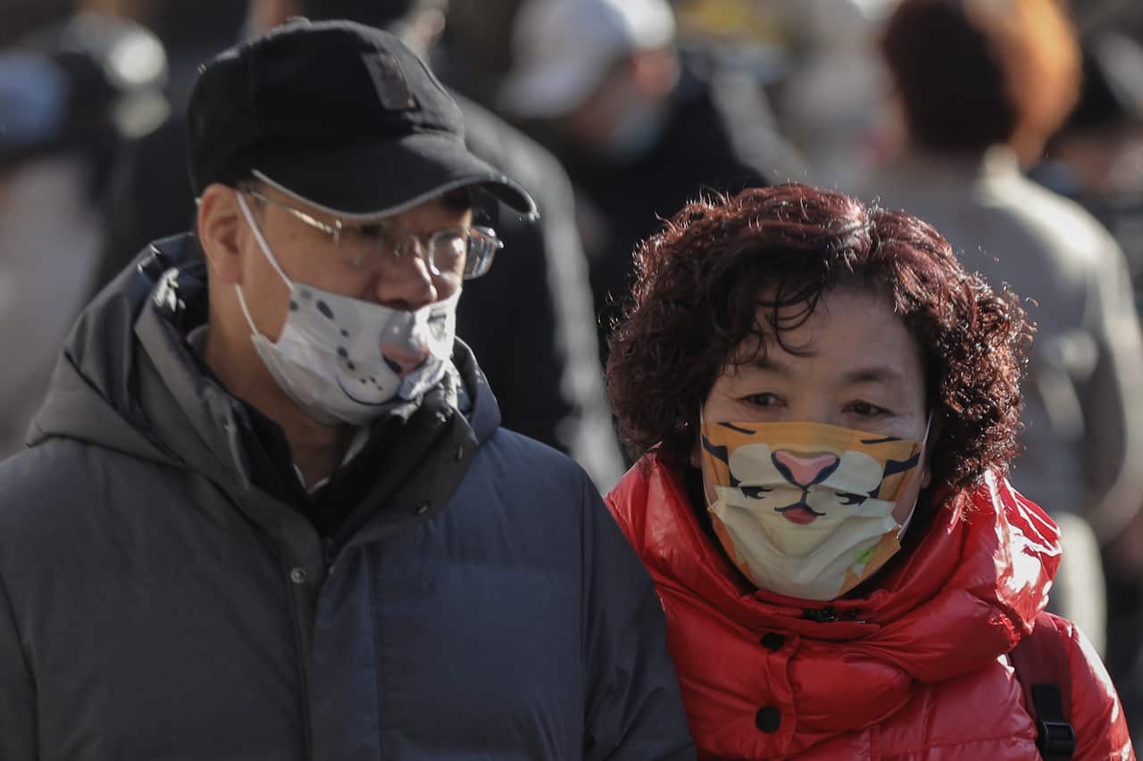 People wear protective face masks with tiger prints at Qianmen commercial street on the first day of the Chinese lunar new year in Beijing, China, 01 February 2022.