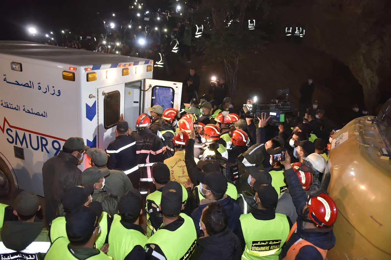 epa09730956 Rescue workers carry the body of 5-year-old Rayan and place it in an ambulance after it was recovered from a well in which he was stuck for several days, in the village of Ighran in Morocco's Chefchaouen province, 05 February 2022. The body of