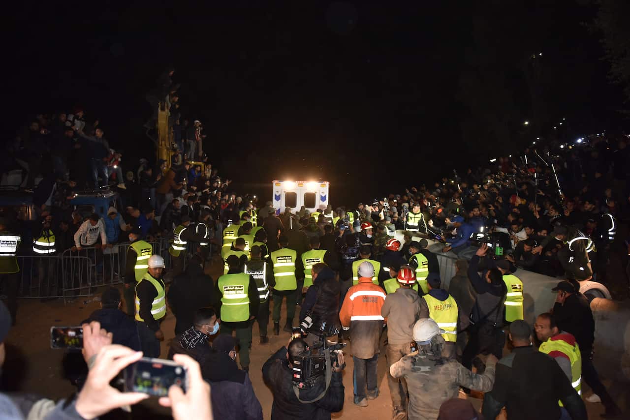 epa09730954 Rescue workers carry the body of 5-year-old Rayan and place it in an ambulance after it was recovered from a well in which he was stuck for several days, in the village of Ighran in Morocco's Chefchaouen province, 05 February 2022. The body of