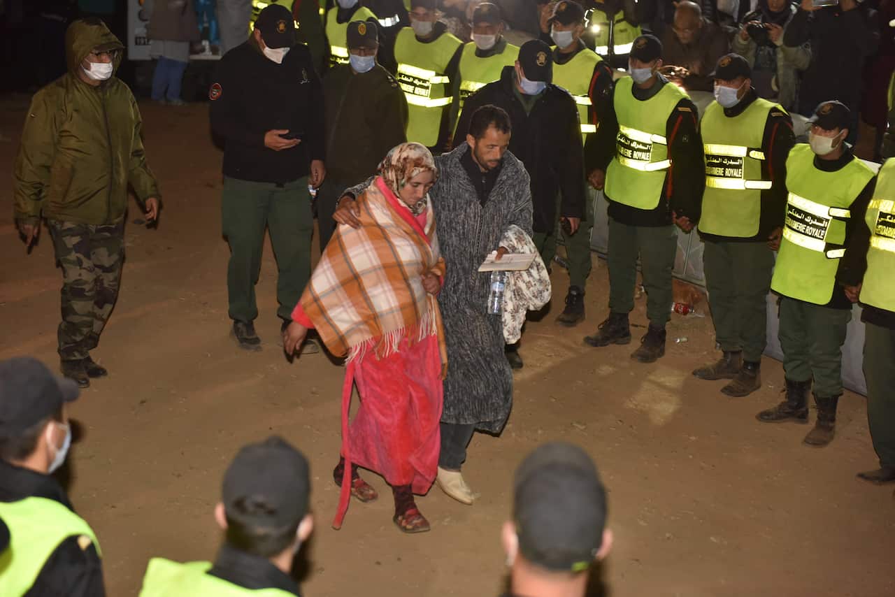 epa09730962 The parents of 5-year-old Rayan are seen after rescue workers carried his body and place it in an ambulance after it was recovered from a well in which he was stuck for several days, in the village of Ighran in Morocco's Chefchaouen province, 